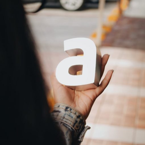 tilt shift lens photography of person holding a letter
